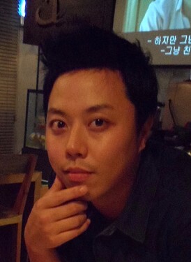 A person is sitting at a table, resting their chin on their hand, looking thoughtful, with a projected image visible in the background. (Captioned by AI)